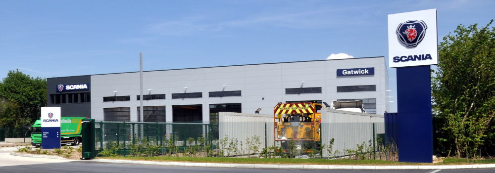 A rectangular grey building with signs reading: Scania Gatwick